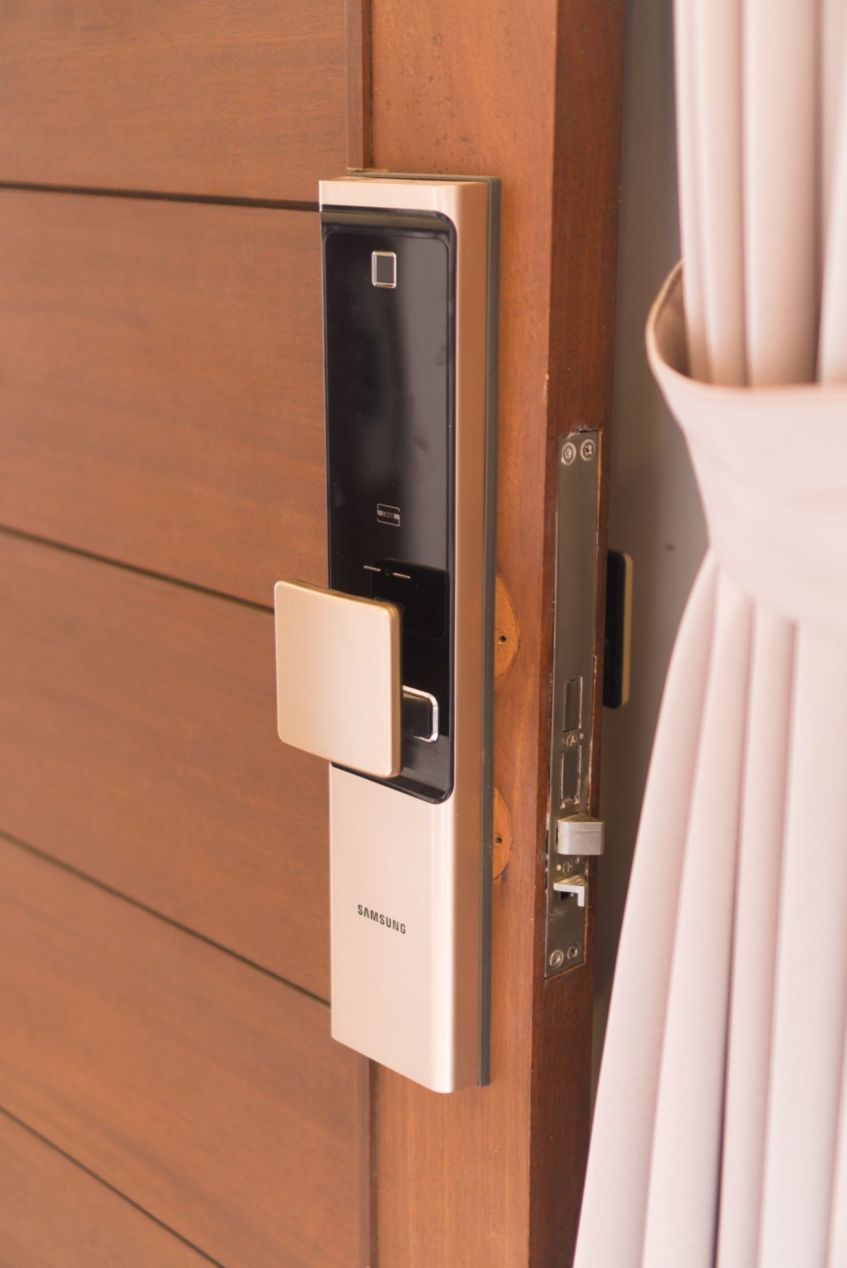 Smart lock with fingerprint reader and keypad on a wooden door